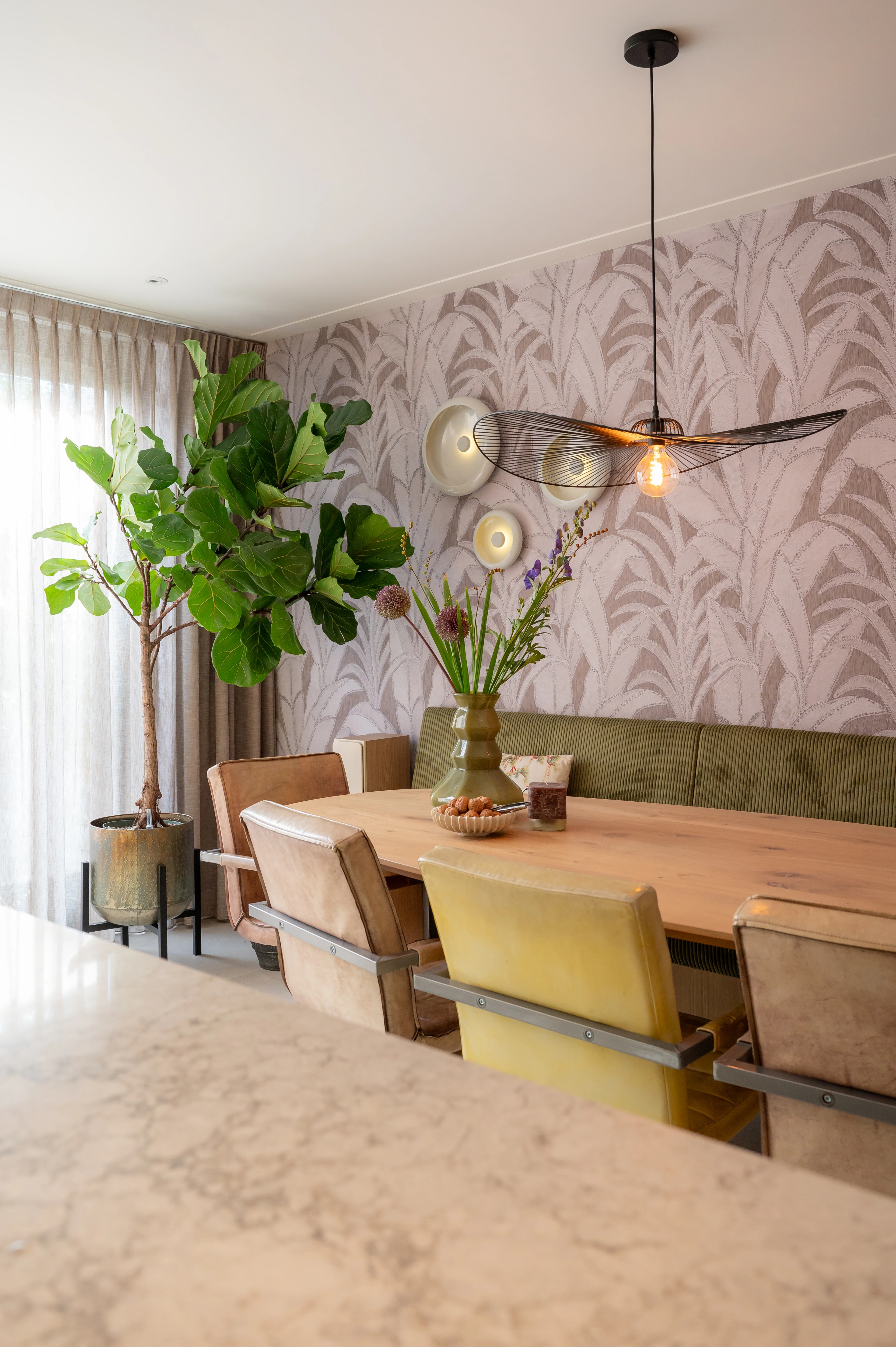 Houten eethoek met groene bank en botanisch behang